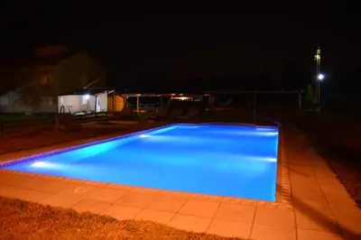 a large blue swimming pool at night at Atahualpa mi Posada in Mina Clavero