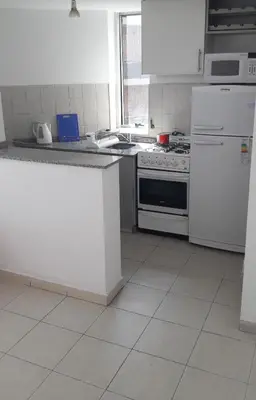 a kitchen with a stove and a white refrigerator at Espacio C Ambrosio Olmos in Cordoba