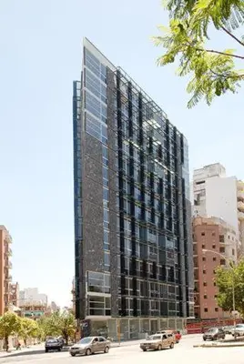 a tall building with cars parked in front of it at Espacio C Ambrosio Olmos in Cordoba