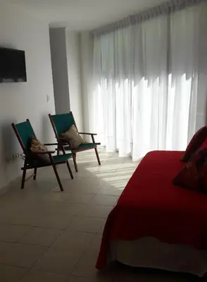 a bedroom with two chairs and a bed and windows at Espacio C Ambrosio Olmos in Cordoba