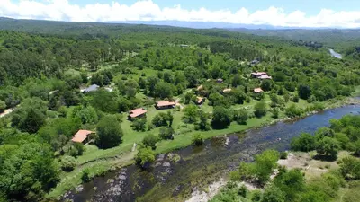 an aerial view of a village next to a river at El Rodeo Apart Cabañas in Santa Rosa de Calamuchita