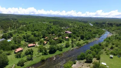 an aerial view of a village and a river at El Rodeo Apart Cabañas in Santa Rosa de Calamuchita