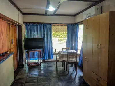 a living room with a table and blue curtains at La Casita Alquiler Temporario in Merlo