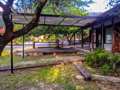 a pavilion with a picnic table and a tree at La Casita Alquiler Temporario in Merlo