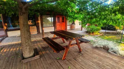 a wooden picnic table and bench next to a tree at La Casita Alquiler Temporario in Merlo