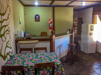 a kitchen with a table and a counter with a refrigerator at La Casita Alquiler Temporario in Merlo