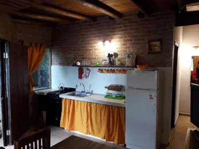 a kitchen with a sink and a refrigerator at Magma Village in Los Reartes