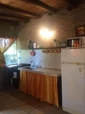 a kitchen with a sink and a refrigerator at Magma Village in Los Reartes