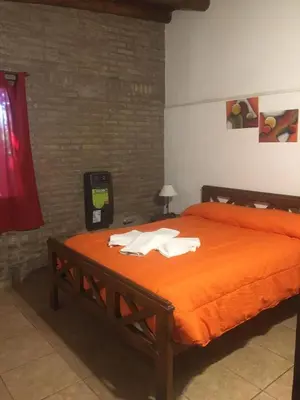a bedroom with a bed with an orange comforter at Magma Village in Los Reartes