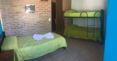 a room with two bunk beds and a brick wall at Magma Village in Los Reartes