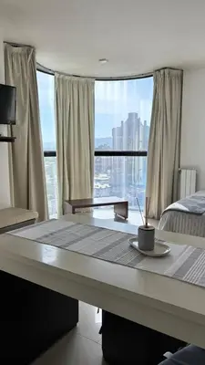 a bedroom with a bed and a large window at Apart Riviera Tower Suites in Villa Carlos Paz