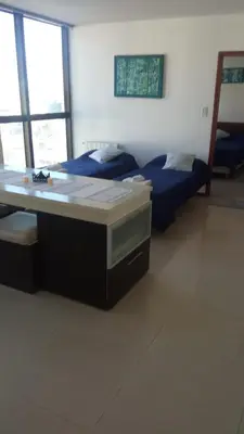 a room with two beds and a desk in it at Apart Riviera Tower Suites in Villa Carlos Paz
