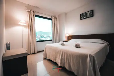 a bedroom with a bed and a large window at Apart Riviera Tower Suites in Villa Carlos Paz