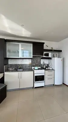 a kitchen with white appliances and black cabinets at Apart Riviera Tower Suites in Villa Carlos Paz
