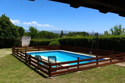 a pool with a wooden fence around it at Vista del sol in Villa Ciudad Parque