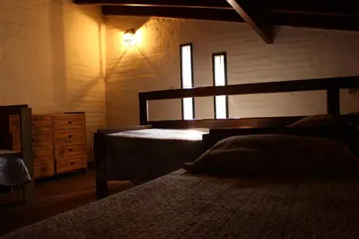 a bedroom with two beds and a dresser and two windows at Vista del sol in Villa Ciudad Parque
