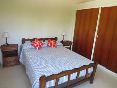 a bedroom with a bed with red and white pillows at Casa en Villa Los Aromos in La Bolsa