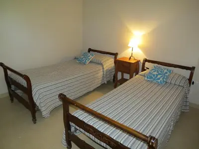 two beds in a room with a lamp on a table at Casa en Villa Los Aromos in La Bolsa