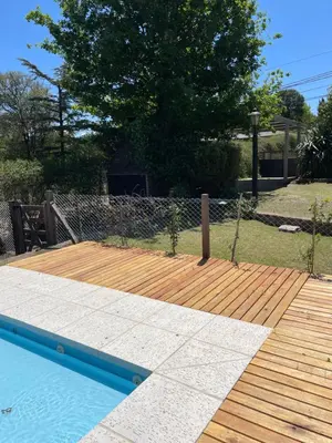 a wooden deck next to a swimming pool at La Elina in Villa General Belgrano