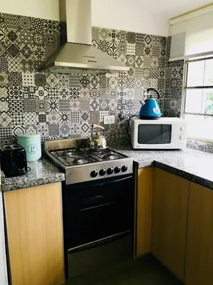 a kitchen with a stove and a microwave at La Elina in Villa General Belgrano