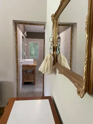 a mirror hanging on a wall next to a bathroom at La Elina in Villa General Belgrano