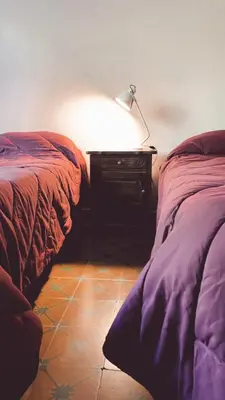 a desk with a lamp next to two beds at La Elina in Villa General Belgrano