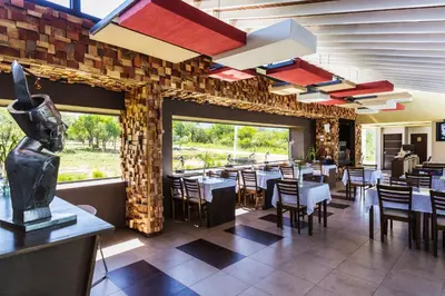 a dining room with tables and chairs in a restaurant at A Hotel Decosuites in Merlo