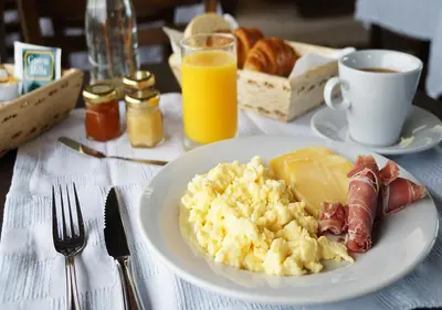 a white plate of breakfast food on a table at A Hotel Decosuites in Merlo