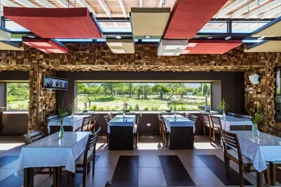 a dining room with tables and chairs and windows at A Hotel Decosuites in Merlo