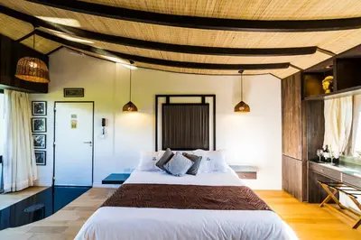 a bedroom with a large bed with a wooden ceiling at A Hotel Decosuites in Merlo