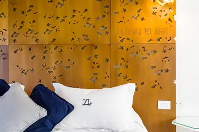 a bedroom with a bed with birds on the wall at A Hotel Decosuites in Merlo