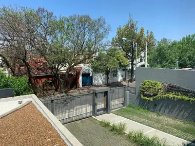 a house with a gate and a fence at Ciudad Prado Hotel in Cordoba