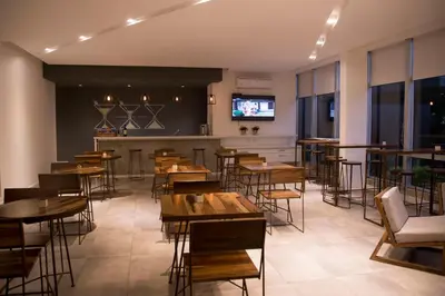a restaurant with tables and chairs and a bar at Ciudad Prado Hotel in Cordoba
