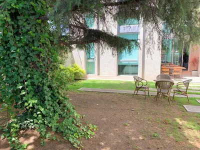a table and chairs sitting under a tree in a yard at Ciudad Prado Hotel in Cordoba