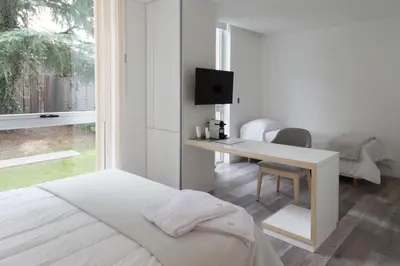 a bedroom with a bed and a desk with a television at Ciudad Prado Hotel in Cordoba