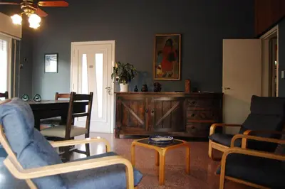 a living room with chairs and a table and a piano at Casa Monty in Mina Clavero