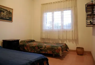 a bedroom with two beds and a window at Casa Monty in Mina Clavero