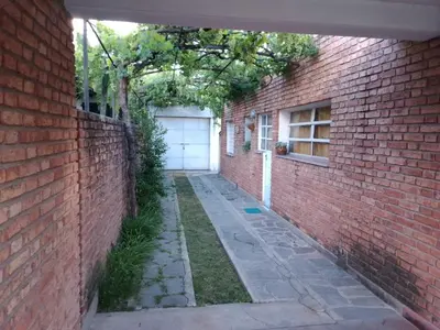 an alley with a white garage door and a brick wall at Casa Monty in Mina Clavero