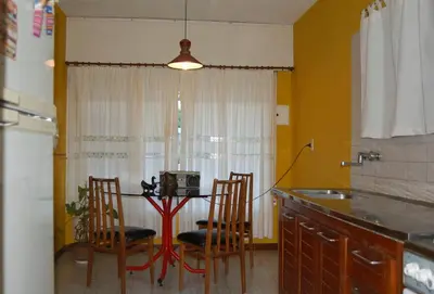 a kitchen with a table and two chairs and a table with a microwave at Casa Monty in Mina Clavero