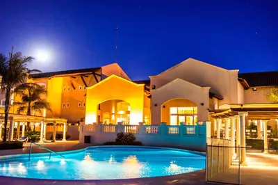 a large house with a swimming pool at night at Howard Johnson Resort Spa & Convention Center in Merlo