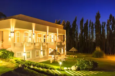 a large white building with a yard at night at Howard Johnson Resort Spa & Convention Center in Merlo