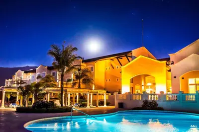 a large house with a swimming pool in front of it at Howard Johnson Resort Spa & Convention Center in Merlo