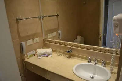 a bathroom with a sink and a mirror at Howard Johnson Resort Spa & Convention Center in Merlo