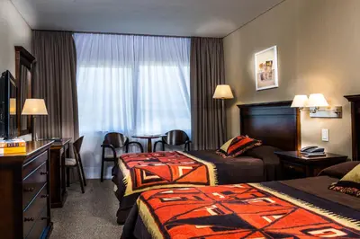 a hotel room with two beds and a table at Howard Johnson Resort Spa & Convention Center in Merlo