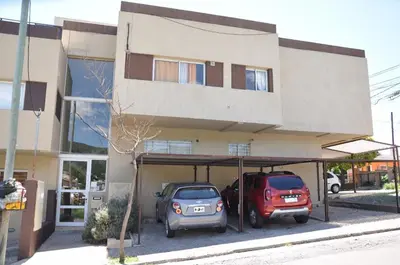 two cars parked in a garage in front of a building at Departamento de alquiler temporario in Villa Carlos Paz