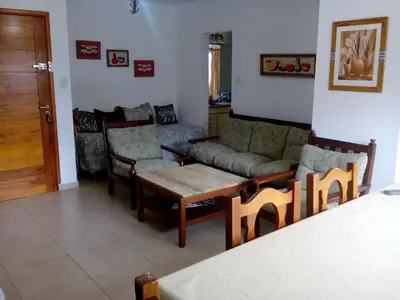 a living room with a couch and a table and chairs at Departamento de alquiler temporario in Villa Carlos Paz