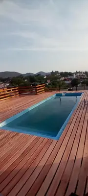 a swimming pool on a deck with a wooden floor at Departamento de alquiler temporario in Villa Carlos Paz