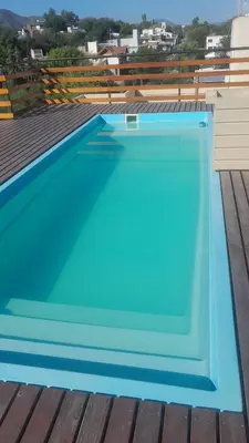 a blue swimming pool on the roof of a house at Departamento de alquiler temporario in Villa Carlos Paz