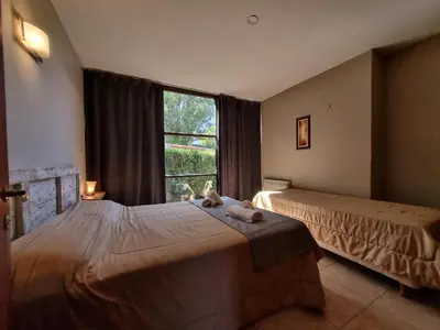 a bedroom with two beds and a large window at Apartamentos Andrea in Villa General Belgrano