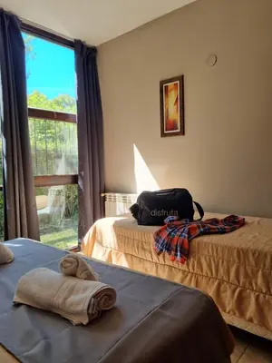 a bedroom with two beds and a window with a view at Apartamentos Andrea in Villa General Belgrano